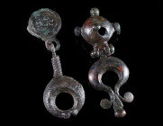 A ROMAN BRONZE STUD FROM A MILITARY BELT AND A FITTING Circa 1st century AD, and 2nd century AD. A stud (bulla), decorated with a head in relief and a...