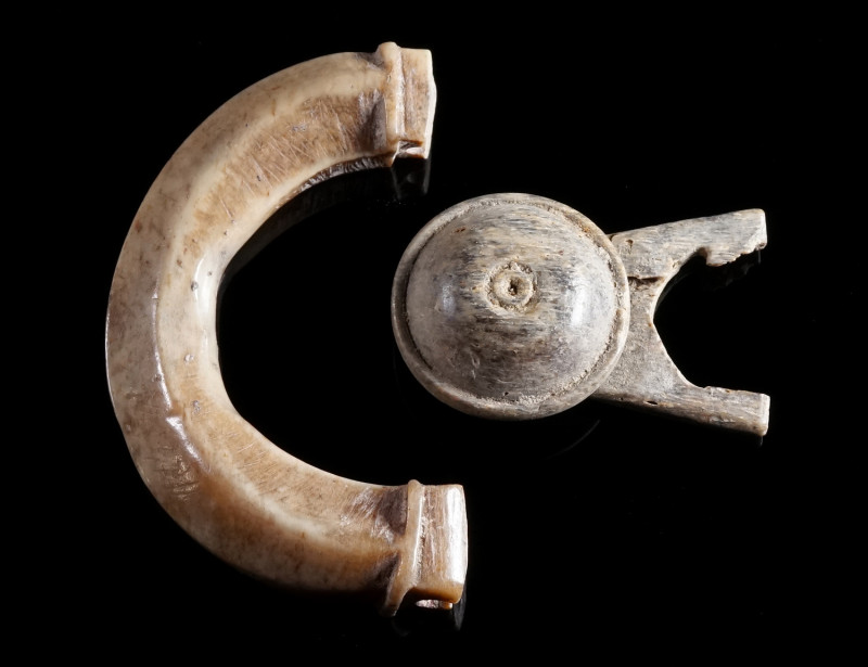 A ROMAN BONE BUCKLE AND A BUTTON AND LOOP FASTENER Circa 1st-2nd century AD. Fra...