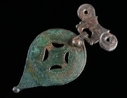 A ROMAN BRONZE MOUNT WITH A DECORATED PENDANT Circa 2nd-3rd century AD. Pendant decorated with a punched design. Probably from a horse harness. H 79 m...