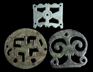 A GROUP OF THREE ROMAN BRONZE MOUNTS/FITTINGS Circa 2nd-3rd century AD, and 4th-5th century AD. Two mid-imperial openwork mounts, one with a swastika,...
