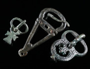A GROUP OF THREE BYZANTINE BRONZE BELT BUCKLES Circa 6th-7th century AD. A small buckle with a cruciform plate, and two buckles with an openwork plate...