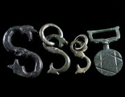 A BRONZE FASTENER AND THREE S-SHAPED BELT HOOKS Circa 12th-14th century AD, and 16th-17th century AD. A medieval button and loop fastener with star de...
