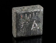 A BYZANTINE BRONZE COMMERCIAL WEIGHT OF ONE OUNCE Circa 5th-7th century AD. Square weight with letters inlaid in silver. The letters ΓΑ stand for 1 ou...