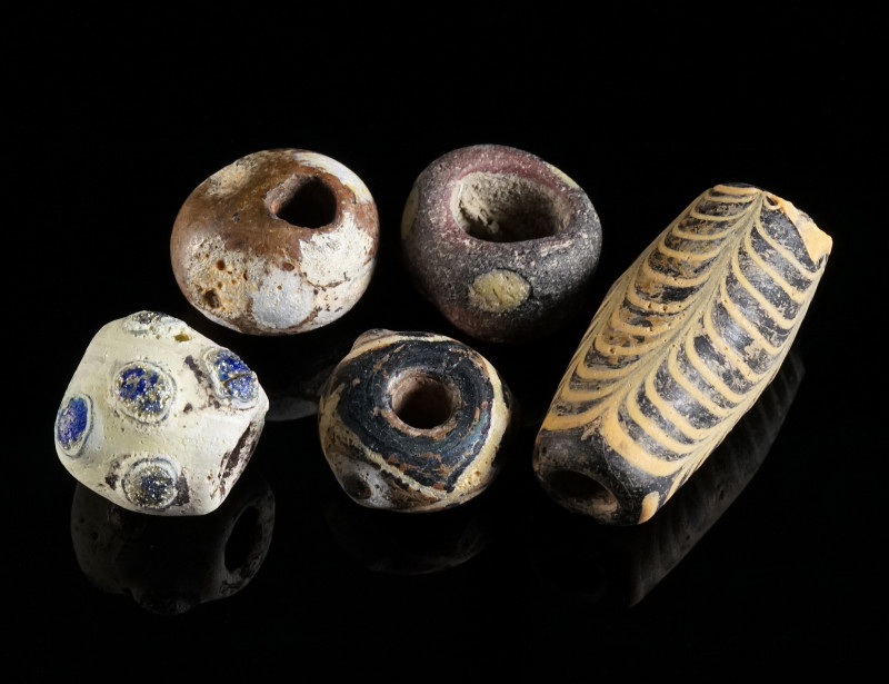 FIVE ANCIENT GLASS BEADS Circa 6th-2nd century BC. One eye bead, the eyes with b...