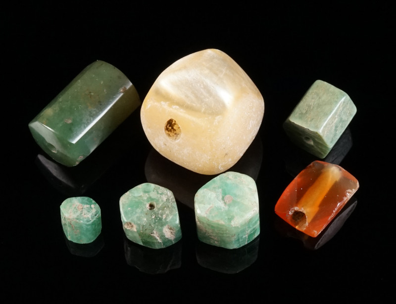 A GROUP OF SEVEN ANCIENT BEADS Circa 1st-4th century AD. Three hexagonal emerald...