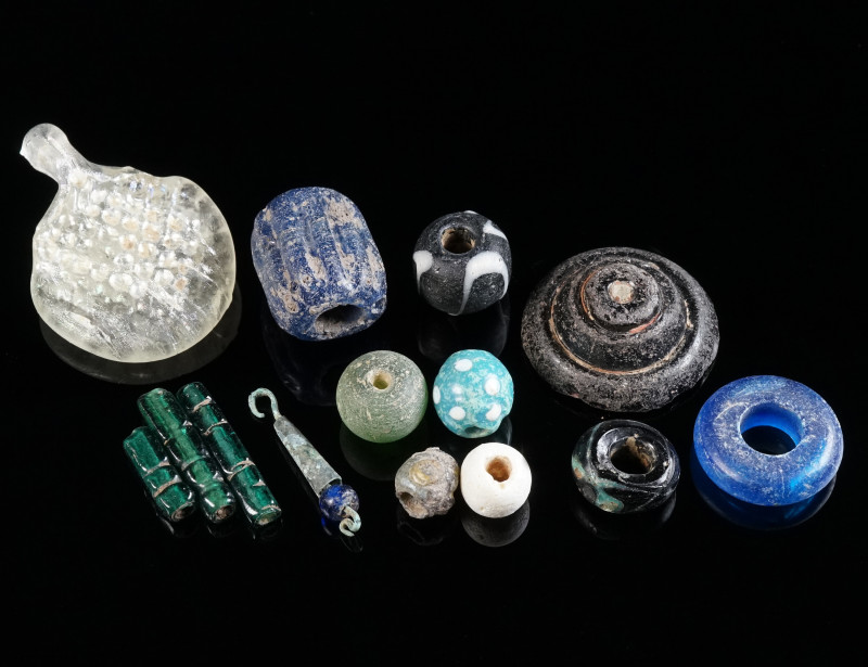 A GROUP OF FOURTEEN SMALL GLASS OBJECTS Circa 4th century BC - 10th century AD (...