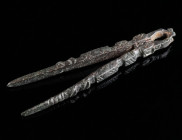 A PAIR OF LATE ANTIQUE/BYZANTINE BRONZE TWEEZERS Circa 4th-7th century AD. Cosmetic tweezers decorated with a series of grooves and incised lines. L 5...