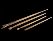 A GROUP OF FOUR ROMAN BONE HAIRPINS Circa 1st-4th century AD. The head of the largest pin is shaped in the form of a hand (three fingers broken), the ...