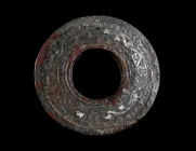 A ROMAN BRONZE LID/UPPER DISK OF AN INKWELL Circa 1st-2nd century AD. An intricately decorated lid of an inkwell with inlaid silver bands of running s...