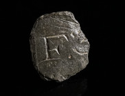 A ROMAN INSCRIPTION REUSED AS A GAMING PIECE Circa 1st-4th century AD. Small part of a bronze tablet with the letter F and the remains of a further le...