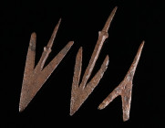 A GROUP OF THREE MEDIEVAL IRON ARROWHEADS Circa 10th-14th century AD. Two swallowtail arrowheads, and one with forked head; all with tang. L 70-103 mm...