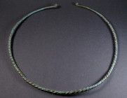 A VERY LARGE EUROPEAN LATE BRONZE AGE TWISTED TORQUE Circa 10th-8th century BC. Twisted hoop of solid bronze, the plain tapering ends with flattened c...