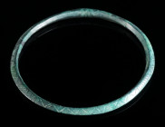A DECORATED EUROPEAN LATE BRONZE AGE BRACELET Circa 10th-8th century BC. Cast bronze bracelet with incised geometric decoration. Beautiful green patin...