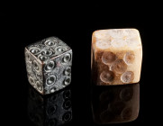 TWO ROMAN GAMBLING/GAMING DICES Circa 1st-3rd century AD. A bronze dice, and a bone dice; both with ring-and-dot design for the pips (eyes). L (edges)...