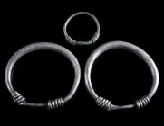 A GROUP OF THREE ROMANO-CELTIC RINGS Circa 1st-2nd century AD. Two large silver rings, and a small bronze ring. Diameter 40 mm each; and Diameter 20 m...