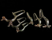 A GROUP OF SIX BYZANTINE BRONZE BROOCHES WITH BENT FOOT Circa 6th-7th century AD. Cast bow brooches with folded foot (umgeschlagenem Fuß), mostly with...