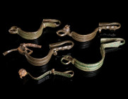 A GROUP OF FIVE BYZANTINE BRONZE BROOCHES WITH BENT FOOT Circa 5th-6th century AD. Bow brooches with folded foot (umgeschlagenem Fuß); some with incis...