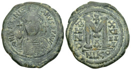 JUSTINIAN I (527-565). Nicomedia. Follis.

Obv : D N IVSTINIANVS P P AVG.
Helmeted and cuirassed bust facing, holding globus cruciger and shield decor...