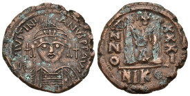 JUSTINIAN I (527-565). Nicomedia. Follis.

Obv : D N IVSTINIANVS P P AVG.
Helmeted and cuirassed bust facing, holding globus cruciger and shield decor...