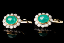 Luxurious yellow and white gold earrings with large emeralds (cabochon cut) surrounded by diamonds. Russia, mid-20th century. The jewelry may have bee...
