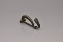 ARQUEOLOGÍA. ROMA. Fíbula de pie vuelto (ss. I-IV d.C.). Bronce. Longitud 6,4 cm.