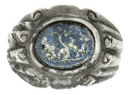 ARQUEOLOGÍA. ROMA. Anillo con montura de hombros marcados decorados con volutas esquemáticas; la cazoleta central alberga un entalle de pasta vítrea i...