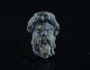 Roman Satyr Head Applique. 2nd-3rd AD century.
A domed bronze mount with a mask facing a bushy-haired, bearded face with silvered eyes, possibly a sat...