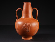 A ROMAN RED SLIP WARE FLASK WITH A GLADIATOR FIGHTING A LION
North Africa, circa 3rd century AD.
Amphora-shaped flask (Amphoriskos) with two strap h...