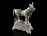 A ROMAN BRONZE STATUETTE OF A BULL
Circa 2nd-3rd century AD.
Statuette of a standing bull set on a profiled rectangular base; cast in one piece. Pro...