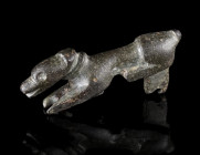 A BYZANTINE BRONZE MOUNT IN THE FORM OF A DOG
Circa 6th-8th century AD.
Mount in the form of a reclining dog with collar. With a loop for attachment...