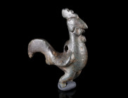 A ROMAN BRONZE PENDANT OF A ROOSTER
Circa 2nd-3rd century AD.
Figurine of a rooster with high crest and long tail feathers; with a suspension loop o...