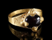 A MEDIEVAL GOLD RING WITH A GARNET
Circa 10th century AD.
Ring with a garnet cabochon in a claw setting. Bezel partly crushed (deformed) and repaire...