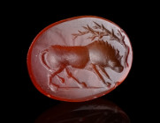 A ROMAN CARNELIAN INTAGLIO WITH A YOUNG BULL
Circa 1st century AD.
Skilfully carved oval intaglio depicting a striding young bull to right and a tre...