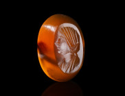 A ROMAN SARD INTAGLIO WITH A FEMALE PORTRAIT BUST
Circa late 2nd - early 3rd century AD.
Oval intaglio featuring the bust of a draped woman with a f...