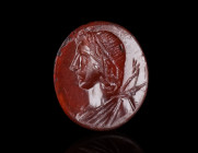 A ROMAN CARNELIAN INTAGLIO DEPICTING A BUST OF APOLLO
Circa 1st-3rd century AD.
Attractive and skilfully carved oval intaglio showing a draped bust ...