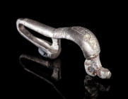 A BYZANTINE SILVER BROOCH WITH BENT FOOT
Circa 6th-7th century AD.
Cast bow brooch with folded foot ('umgeschlagenem Fuß'); incised and punched deco...