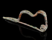 AN IRON AGE BRONZE SERPENTINE FIBULA
Circa 6th-5th century BC.
The bow with incised decoration. With spring and pin. Somewhat corroded and small par...