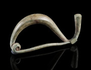 AN IRON AGE/EASTERN CELTIC BRONZE BOW FIBULA
Circa 4th-3rd century BC.
La Tène Type/Thracian Type fibula. Made of one piece with spring and pin; the...