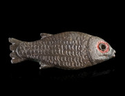 A ROMAN ENAMELLED BRONZE FISH BROOCH
Circa 2nd century AD.
Brooch in the shape of a fish to right. The eye is indicated by a ring of red enamel. The...