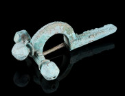 A LATE ROMAN GILT BRONZE CROSSBOW BROOCH
Circa 4th century AD.
With arched bow and facetted onion-shaped terminals ('Zwiebelknöpfe'). Bow and foot d...