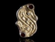 A LANGOBARDIC SILVER-GILT S-SHAPED BROOCH
Circa 6th century AD.
S-shaped brooch with animal headed terminals and garnet inlaid eyes. With chip carve...