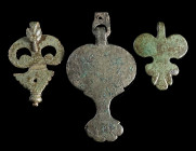 THREE PENDANTS FROM EARLY ROMAN MILITARY HORSE HARNESSES
Circa 1st century AD.
Leaf/pelta-shaped pendants with suspension hook; one with wolf-headed...