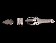 A LATE ANTIQUE/MIGRATION PERIOD SILVER BELT BUCKLE
Circa 5th-6th century AD.
Belt buckle with elongated triangular plate with three rivet holes; and...
