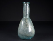 A LARGE ROMAN PALE BLUE-GREEN GLASS BALSAMARIUM
Circa 2nd-3rd century AD.
Balsamarium with pear-shaped body and tall, cylindrical neck with folded d...