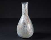 A ROMAN PALE BLUE GLASS BALSAMARIUM
Circa 2nd-3rd century AD.
Balsamarium with pear-shaped body and cylindrical neck with folded disk-rim. The surfa...