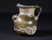 A ROMAN PALE YELLOW-GREEN GLASS JAR WITH TWO HANDLES
Circa 3rd-4th century AD.
Small glass jar with squat globular body, short cylindrical neck, and...