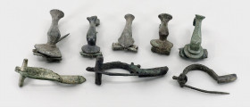 OBJEKTE AUS BRONZE. 
SCHMUCK. 
FIBELN. LOT: 8 Bronze-Fibeln römische Zeit, Scharnierfibel mit großem Bogen aus Pannonien grüne Patina; 2 Scharnierfi...