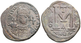 Justinian I AE Follis (Bronze) Antioch. Obv: DN IVSTINIANVS PP AVG, helmeted and cuirassed bust facing, holding cross on globe and shield with horsema...
