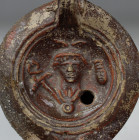 Roman factory oil lamp, Type Bussière B IV 3, depicting bust of Mercury, front, wearing a winged petasus, framed by a caduceus and a purse and makers ...
