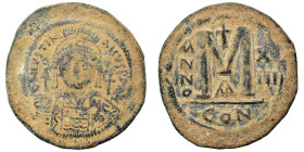 Justinian I, 527-565. Follis (bronze, 22.80 g, 41 mm), Constantinople. Helmeted, draped, and cuirassed bust facing, holding globus cruciger and shield...